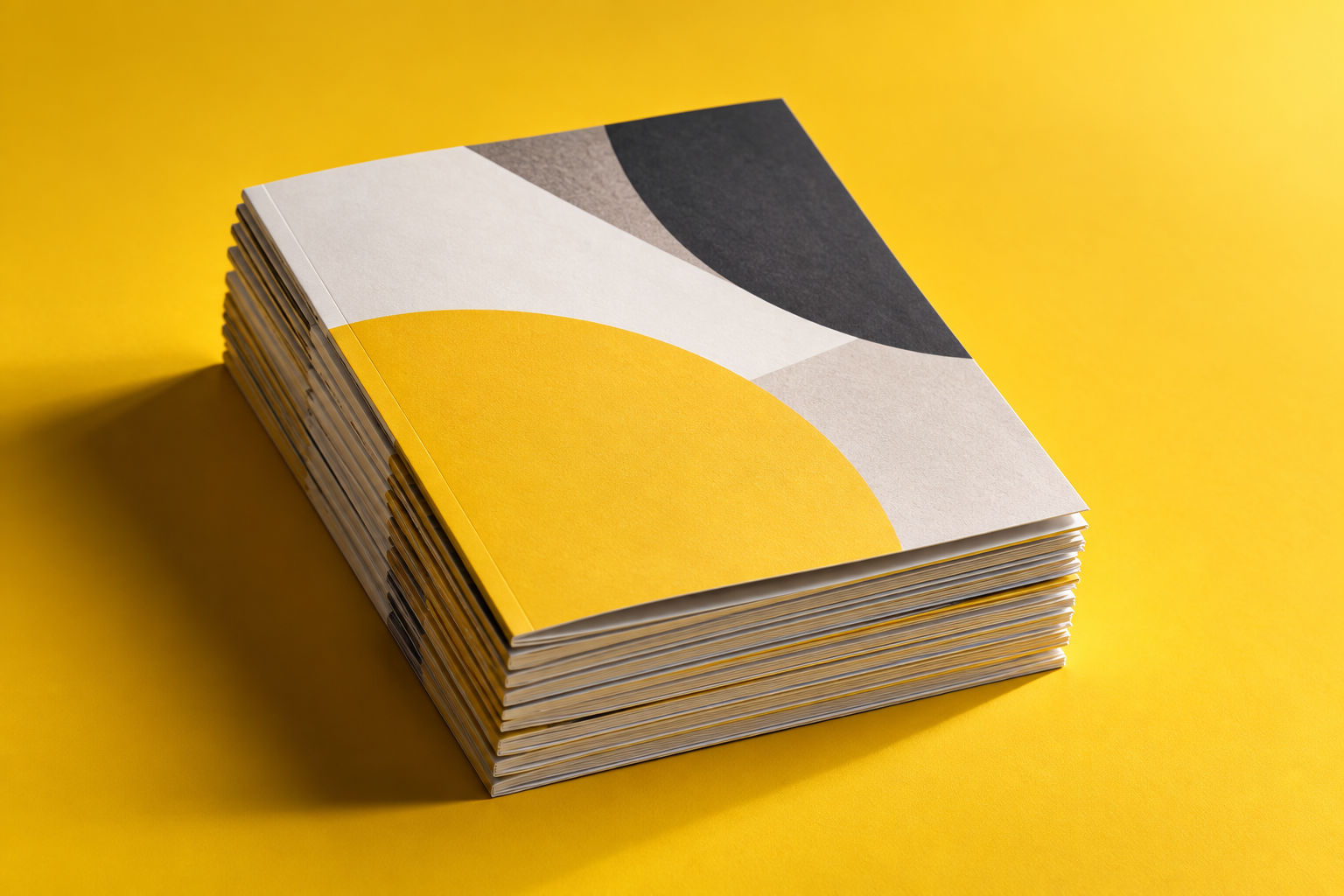 A stack of freshly printed brochures on a yellow ground.